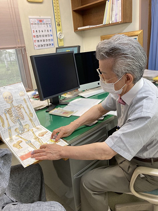 『人体絵本』を用いて患者さまに説明をする院長